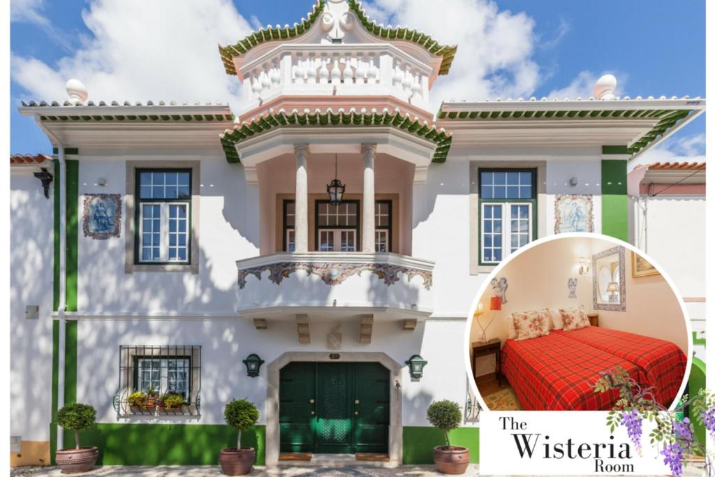 una casa blanca con una cama roja delante en Villa Estefânia em Sintra, en Sintra