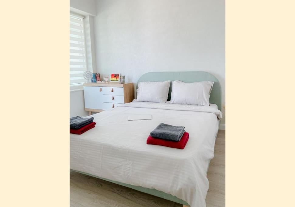 um quarto com uma cama branca e uma toalha vermelha em Royal View Copou 2 rooms AbHomes em Iaşi
