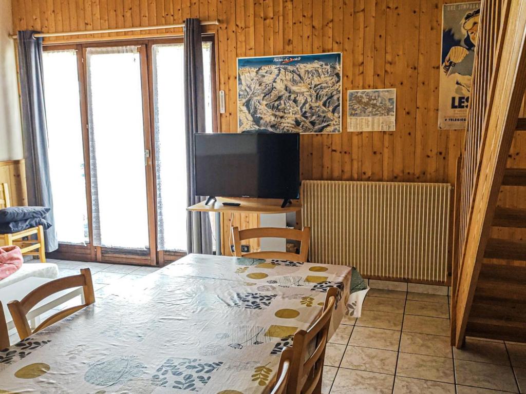 une salle à manger avec une table et une télévision dans l'établissement Grand appartement 8 personnes, animaux admis, parking, proche des pistes - FR-1-671-108, aux Gets