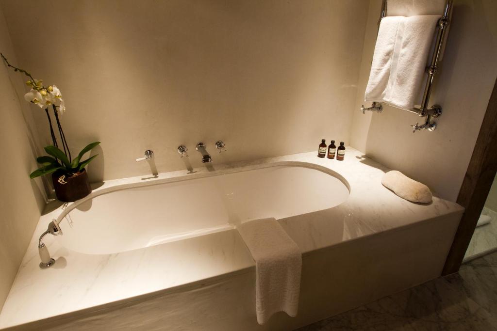 a white bath tub in a bathroom with a plant at Zannier Hotels Le Chalet in Megève