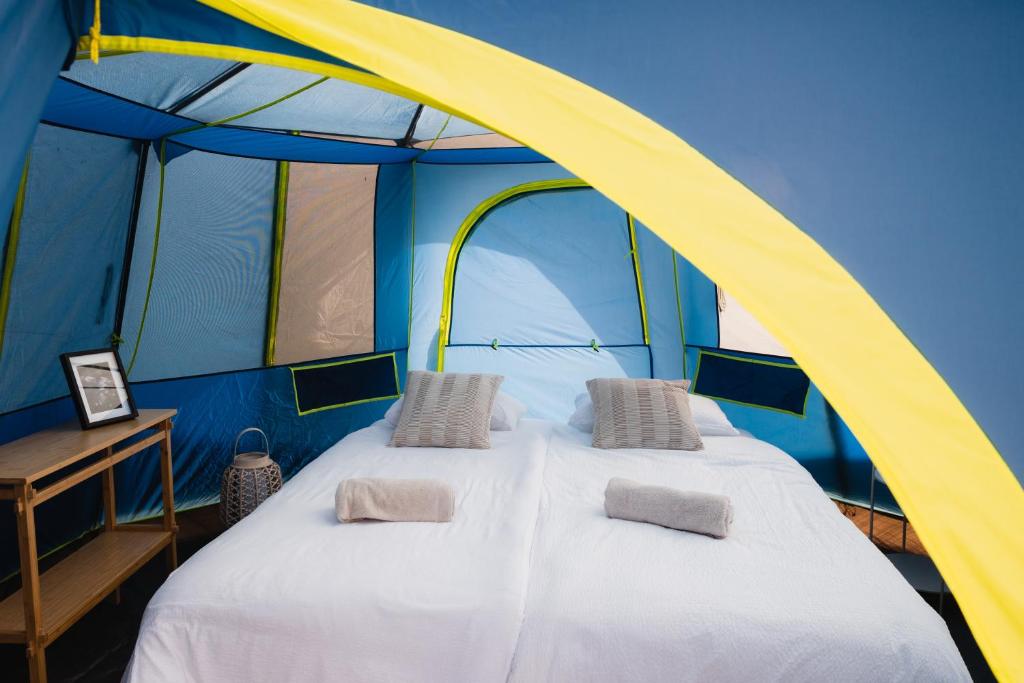 a large bed in a blue and yellow tent at Luxury tent - Villmarkseventyret in Håtvet