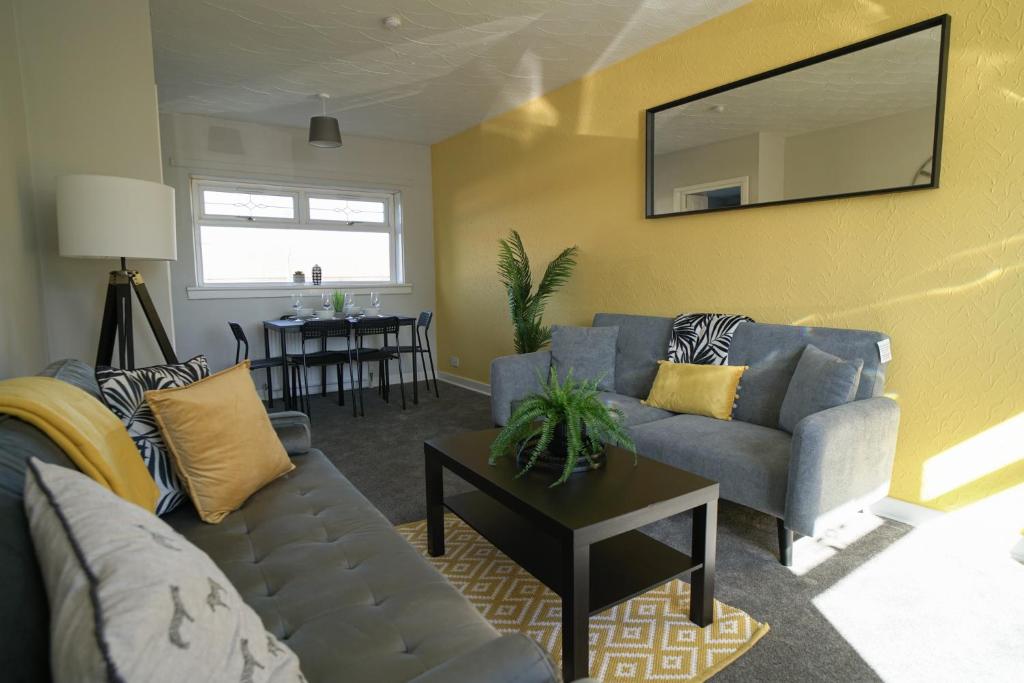ein Wohnzimmer mit einem Sofa und einem Tisch in der Unterkunft McCracken House in Uddingston
