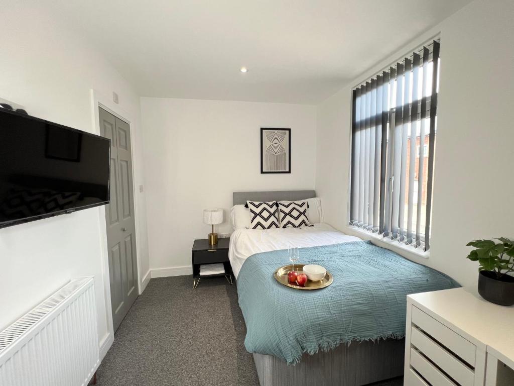 We House - Selly Oak Birmingham في برمنغهام: غرفة نوم بها سرير مع وعاء من الفواكه عليها