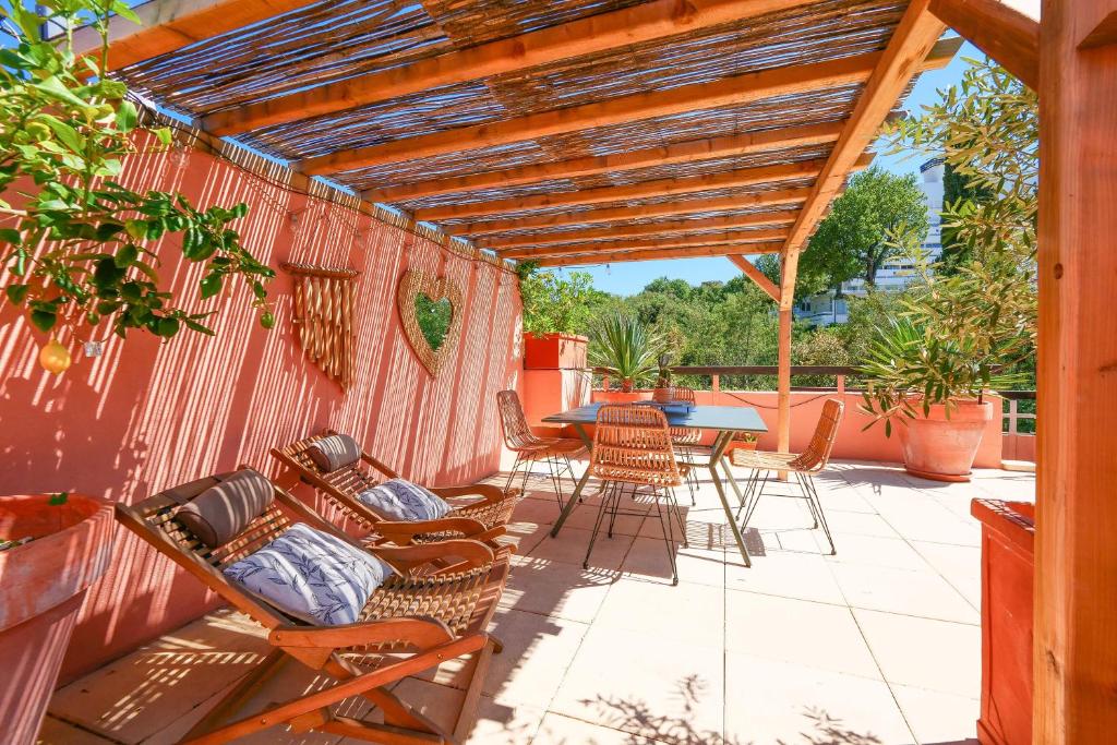 un patio avec une pergola en bois et une table et des chaises dans l'établissement Private Rooftop St Tropez, à Saint-Tropez