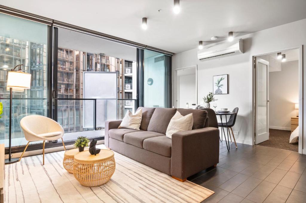 a living room with a couch and a table at Rooftop Pool 2BR Apt at Marvel Stadium with Free Parking in Melbourne