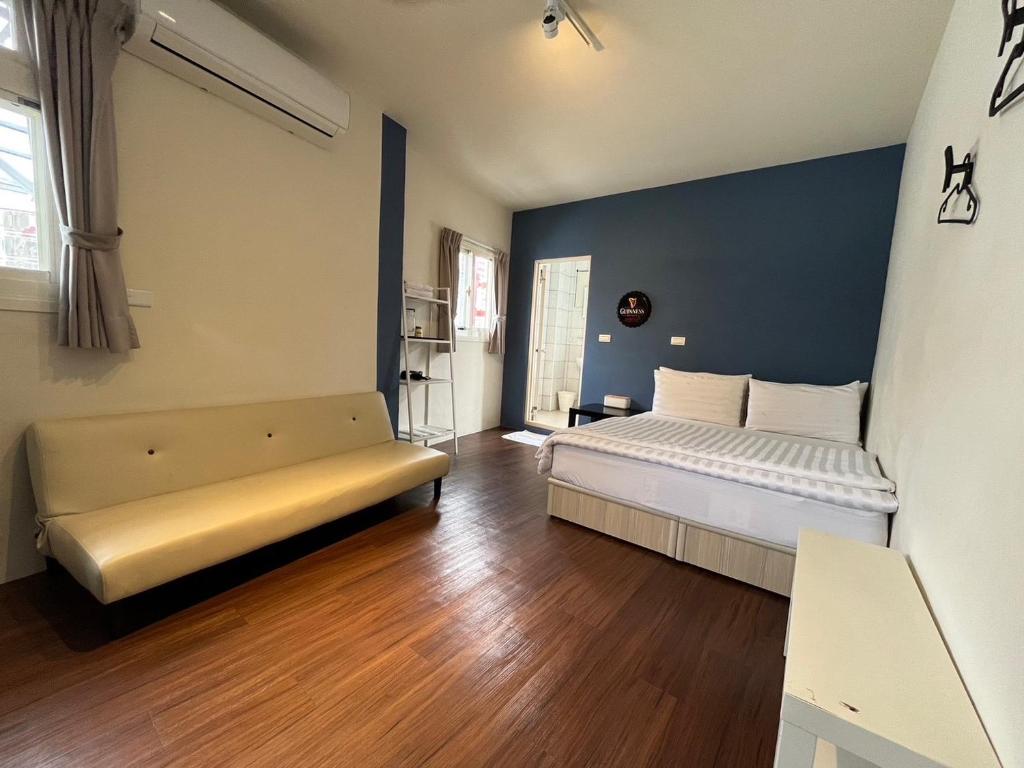 1 dormitorio con cama y sofá en Lazy bone, en Hsinchu City