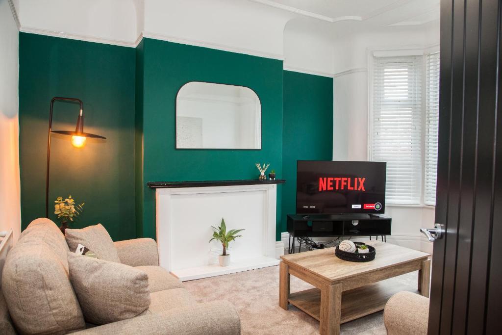 a living room with a couch and a tv at 8 Karslake Road in Wallasey