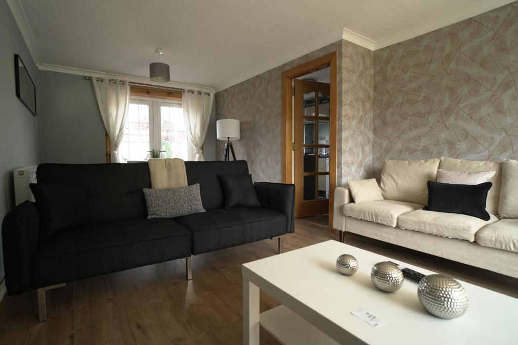 uma sala de estar com um sofá e uma mesa em Ravenswood House em Glenrothes