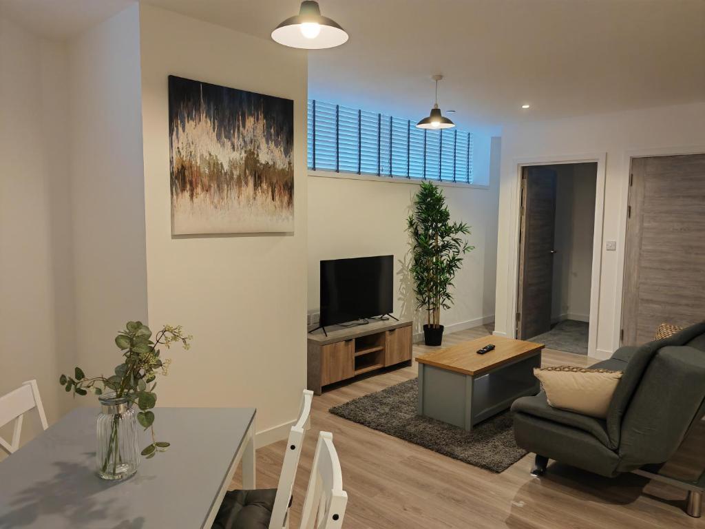 - un salon avec un canapé et une télévision dans l'établissement Bayard Plaza 1 Bedroom Modern Spacious Apartment, à Peterborough