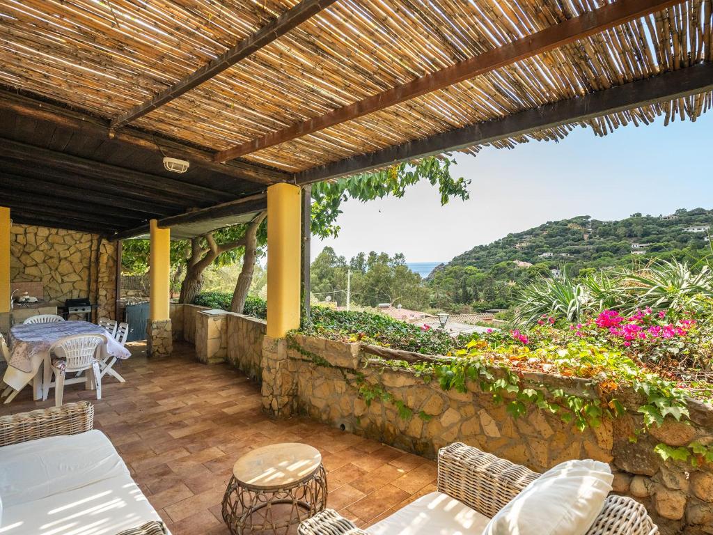 un patio avec des chaises et des tables ainsi qu'un mur en pierre dans l'établissement Villino Valentina Best Vacation Ever, à Torre delle Stelle