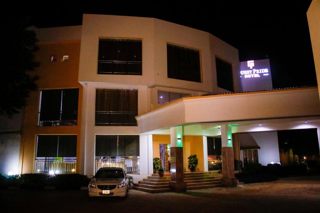 a car parked in front of a building at night at Guest Pride Hotel in Kano