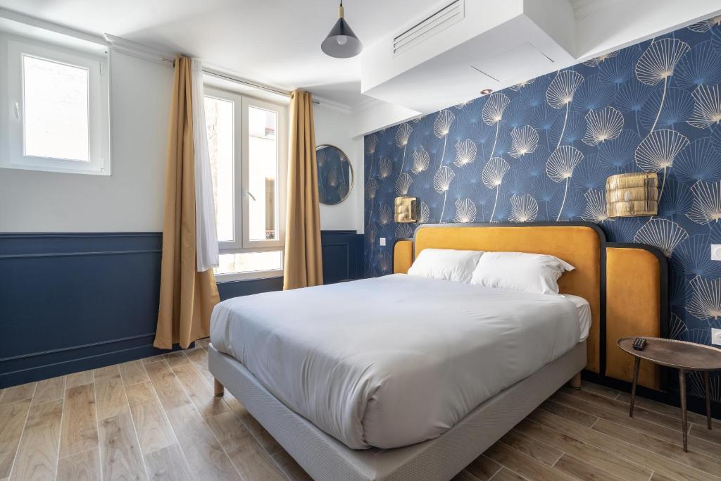 - une chambre avec un lit et un mur bleu dans l'établissement District Nation, à Paris