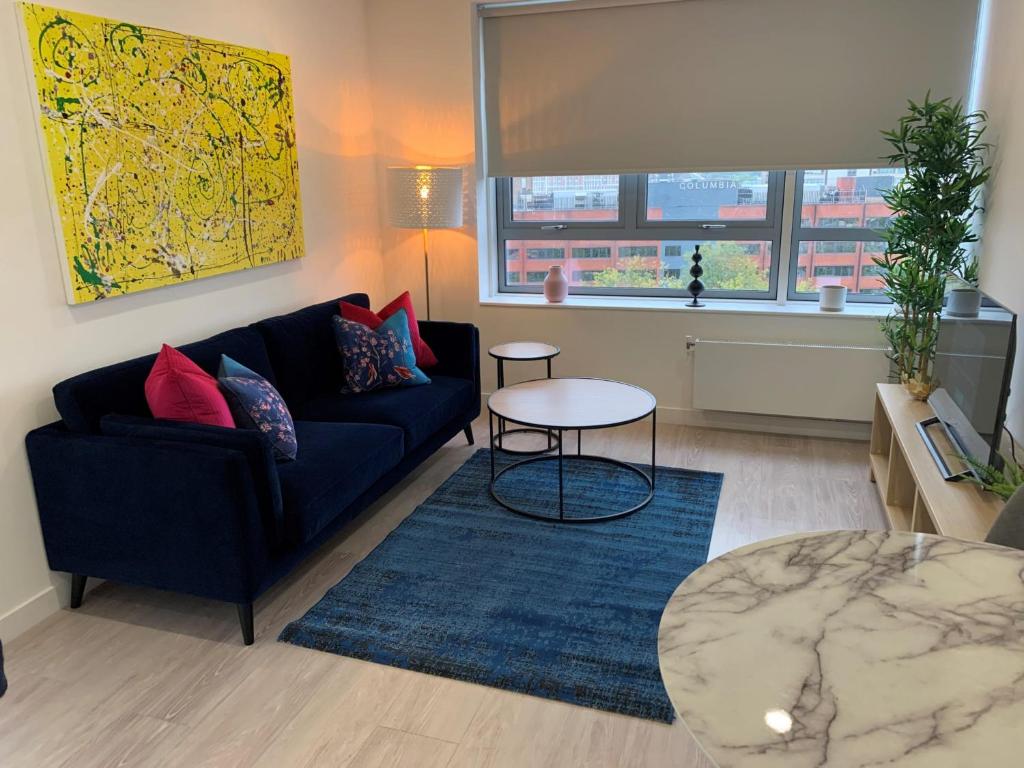 a living room with a couch and a table at Bracknell - A Spectacular Dual Aspect 1 Bedroom Flat in Bracknell