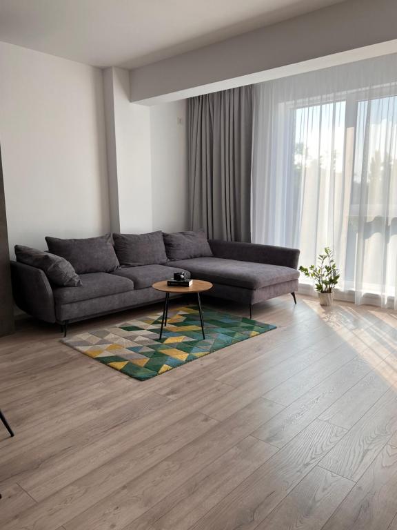 ein Wohnzimmer mit einem Sofa und einem Tisch in der Unterkunft Bright & Modern 3 Room Apartment with All Amenities and Underground parking in Timişoara