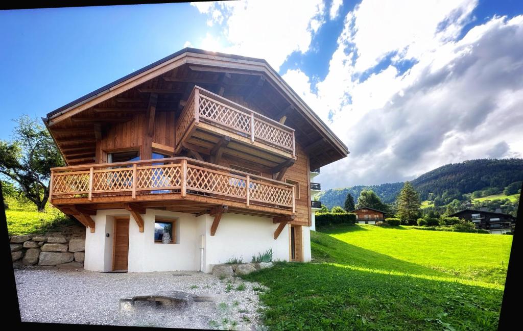 a wooden house with a balcony on top of it at Chalet neuf La Perle du Perron in Cordon