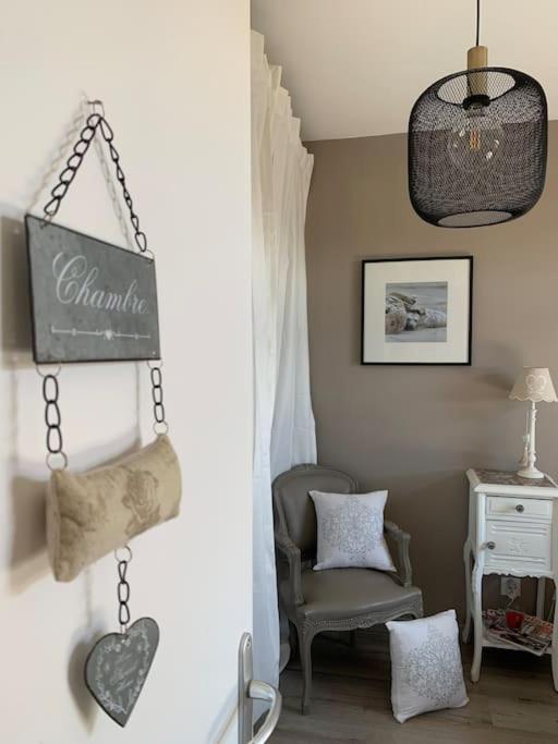 une chambre avec une chaise et un panneau sur le mur dans l'établissement Bienvenue à la maison, à Étaples