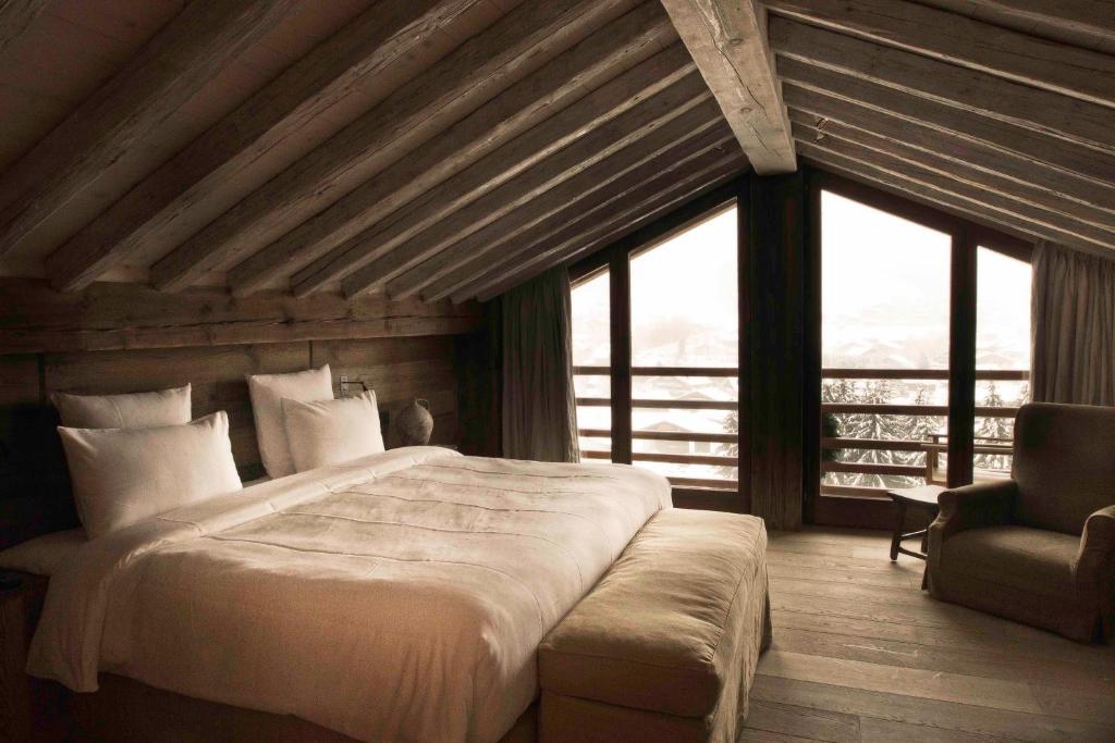 a bedroom with a large bed and a chair at Zannier Hotels Le Chalet in Megève