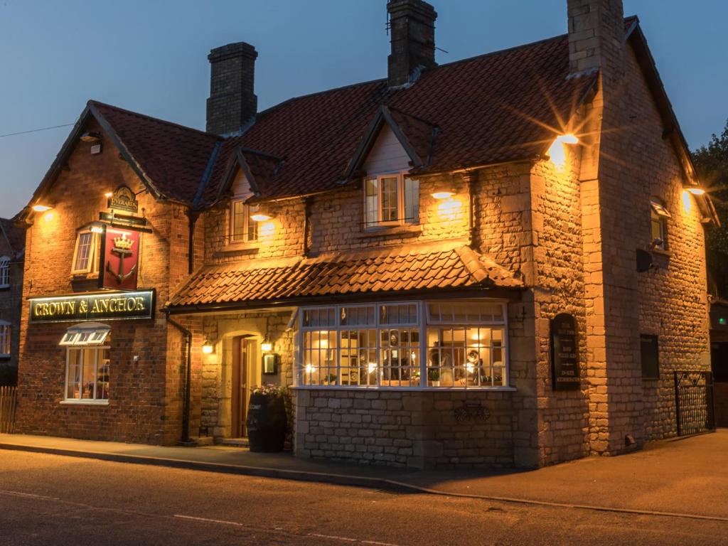 a large brick building on a street at night at Crown & Anchor in Grantham
