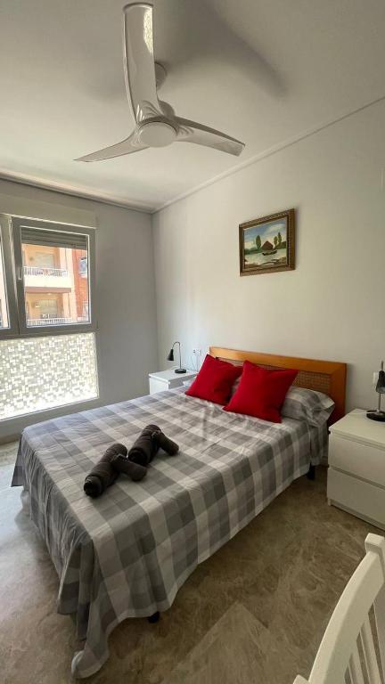 una camera da letto con un grande letto con cuscini rossi di Preciosa a 2 min Renfe a Gandía