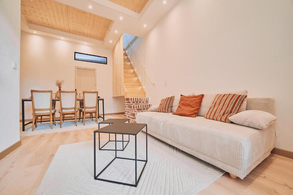 a living room with a white couch and a table at Villa Bewick-Loft Architecte in Saint-Valery-sur-Somme