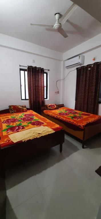 two beds sitting in a room with at Kalawati Niwas in Bodh Gaya