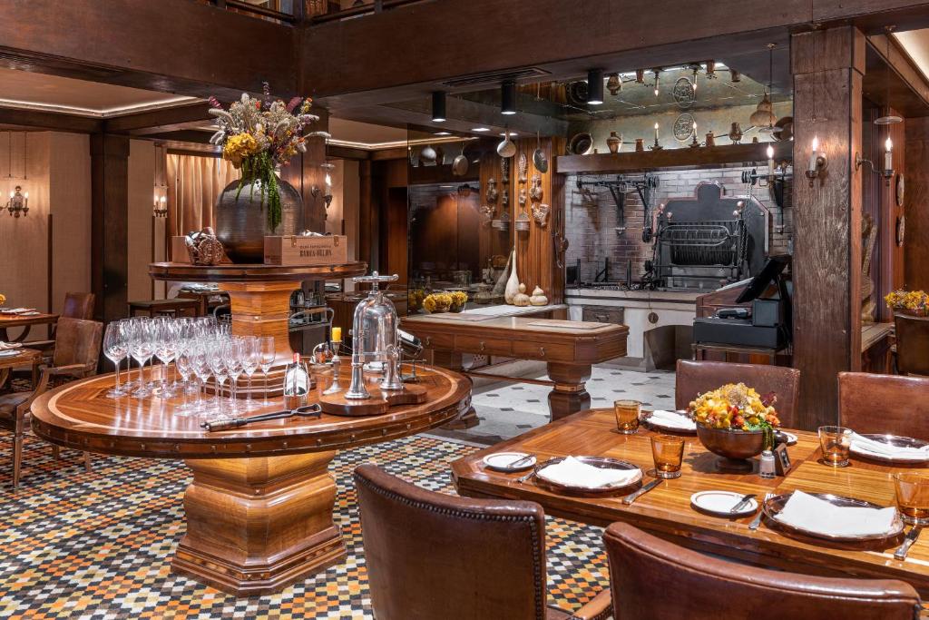 a restaurant with wooden tables and chairs and a kitchen at Palácio Estoril Hotel, Golf & Wellness in Cascais