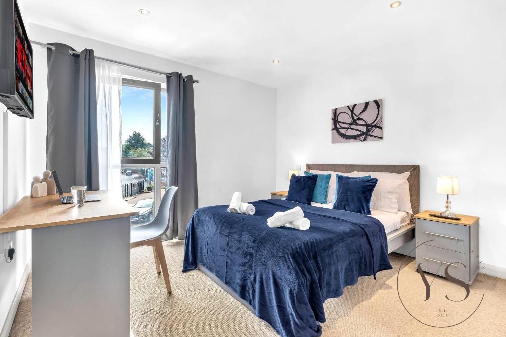 - une chambre avec un lit doté de draps bleus et une fenêtre dans l'établissement Riverside Apartment 2BR - Parking - Wi-Fi -Netflix, à Derby