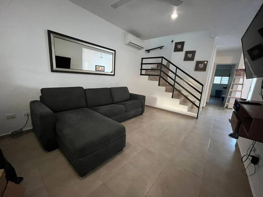 sala de estar con sofá y escalera en Hermosa casa, en Playa del Carmen