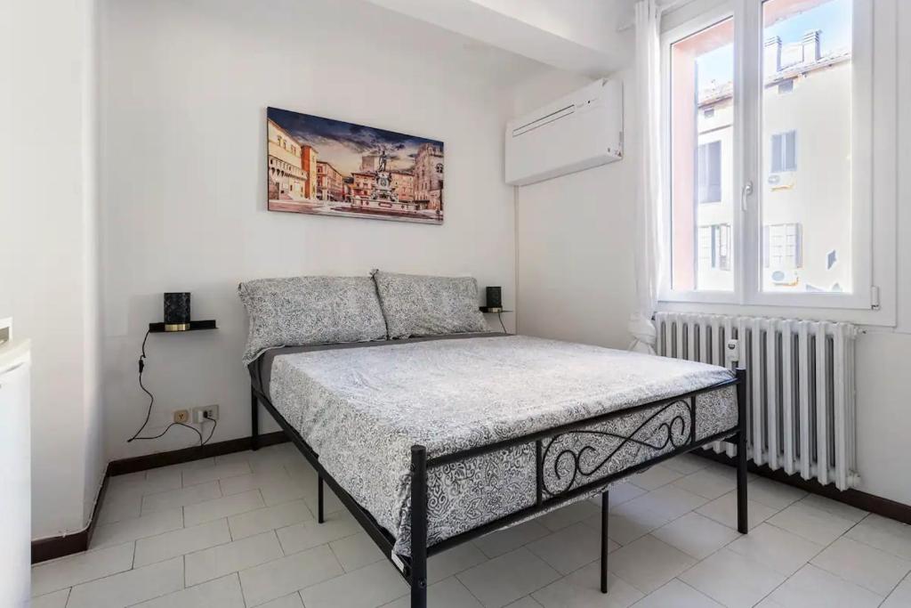 a bedroom with a bed and a window at Appartamento Pescherie - Top location in Bologna