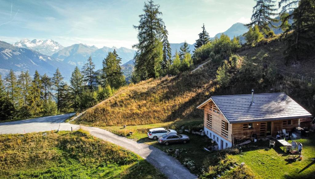 a house on a hill with cars parked in front at Modern chalet surrounded by nature in Vercorin in Vercorin