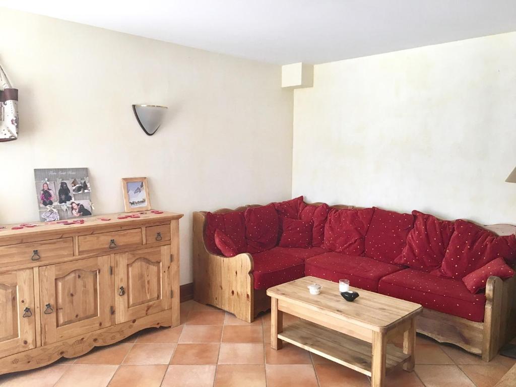 a living room with a red couch and a coffee table at Appartement Corrençon-en-Vercors, 3 pièces, 7 personnes - FR-1-761-7 in Corrençon-en-Vercors