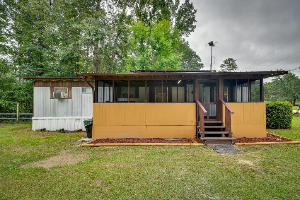 a small house with a yellow wall at Eufaula Retreat Community Pool and Screened Porch! in Eufaula
