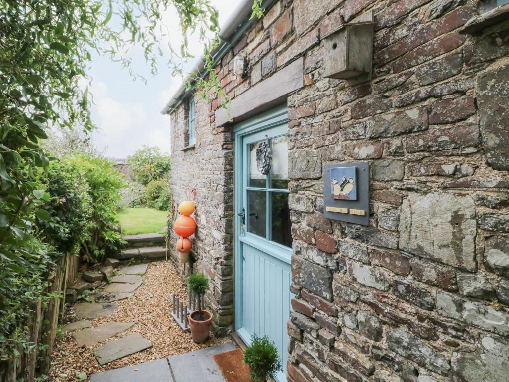 a brick house with a blue door and orange balloons at Puffins Nest in Bideford