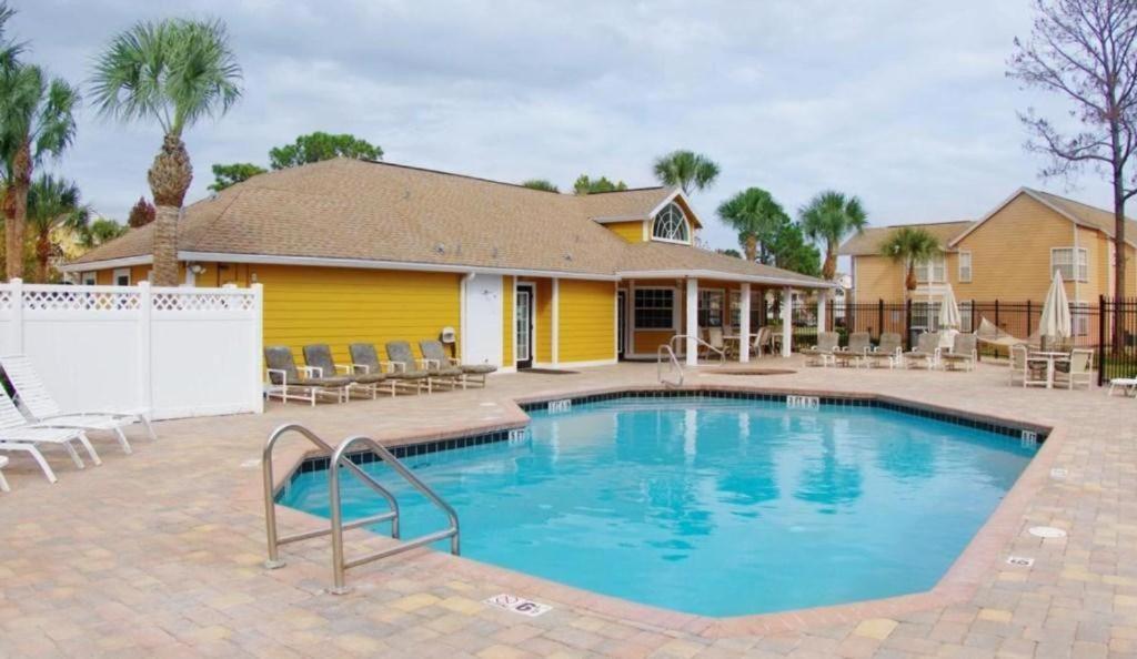 a swimming pool in front of a house at Sweet retreat condo resort in Kissimmee