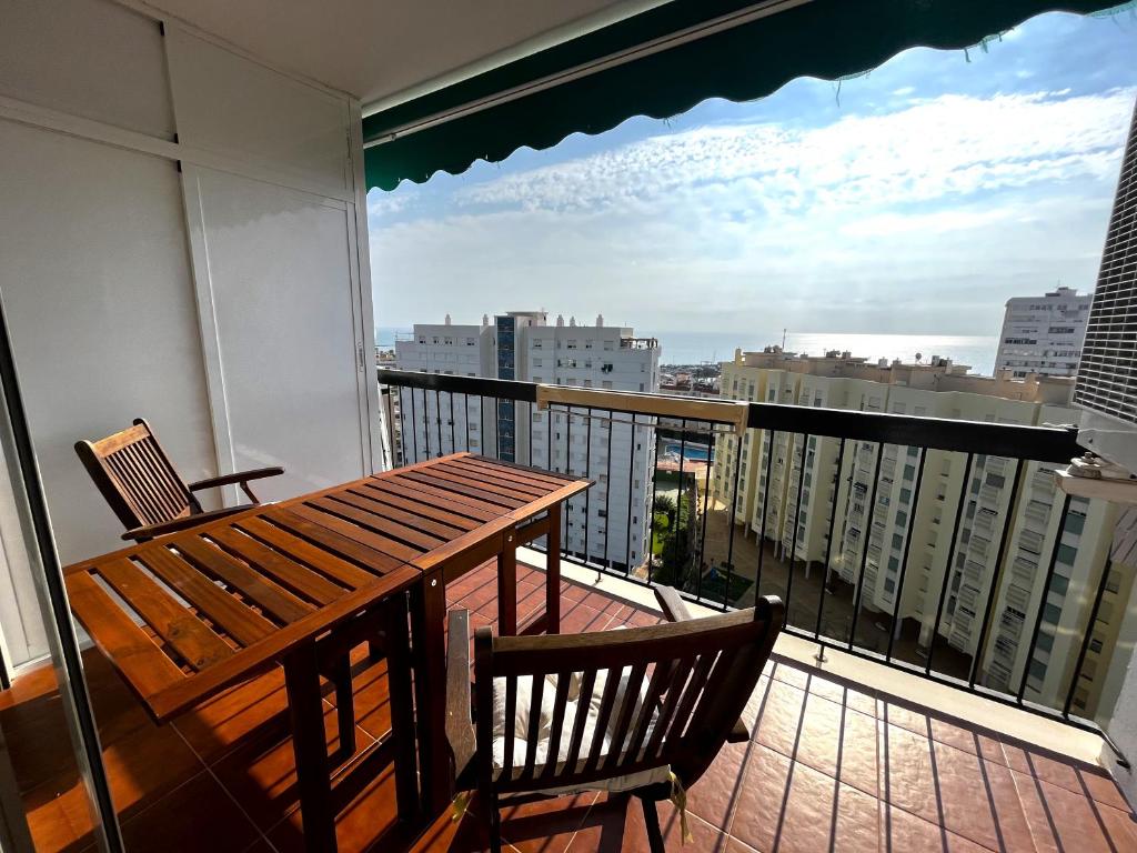 uma varanda com uma mesa de madeira e 2 cadeiras em Elegante alojamiento con piscina y terraza em Valência