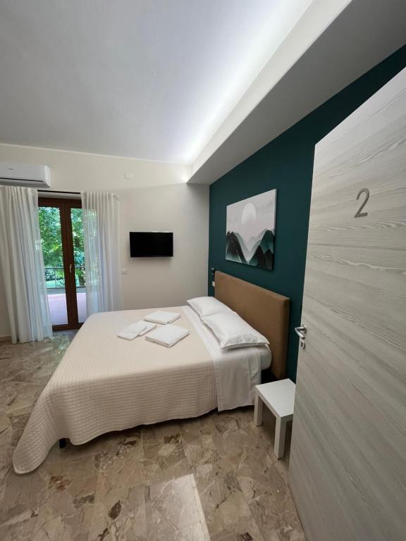 B&B Casa Doria في فالمونتوني: غرفة نوم بسرير كبير وتلفزيون