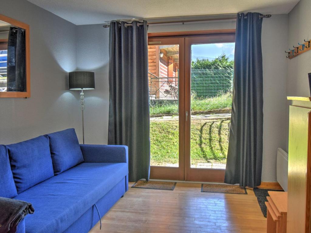 - un salon avec un canapé bleu et une porte coulissante en verre dans l'établissement Studio cosy pour 4 pers avec terrasse, à 300m des pistes, centre de Morzine - FR-1-524-108, à Morzine