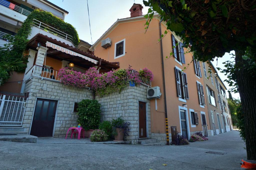 a building with flowers on the side of it at Apartments Lory in Rabac