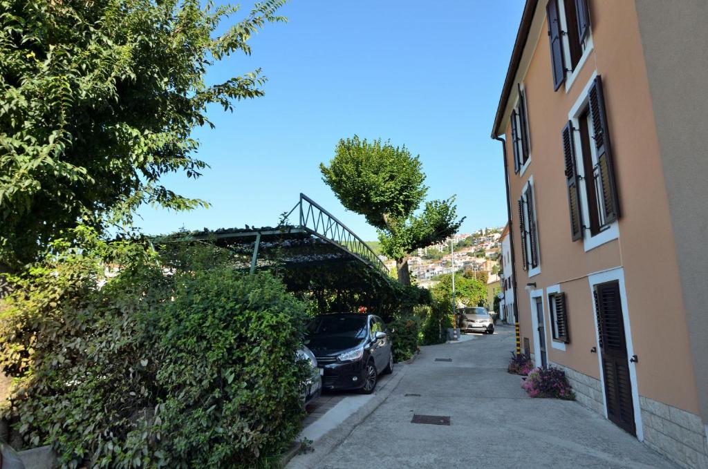 un'auto parcheggiata in una strada accanto a un edificio di Apartments Lory a Rabac