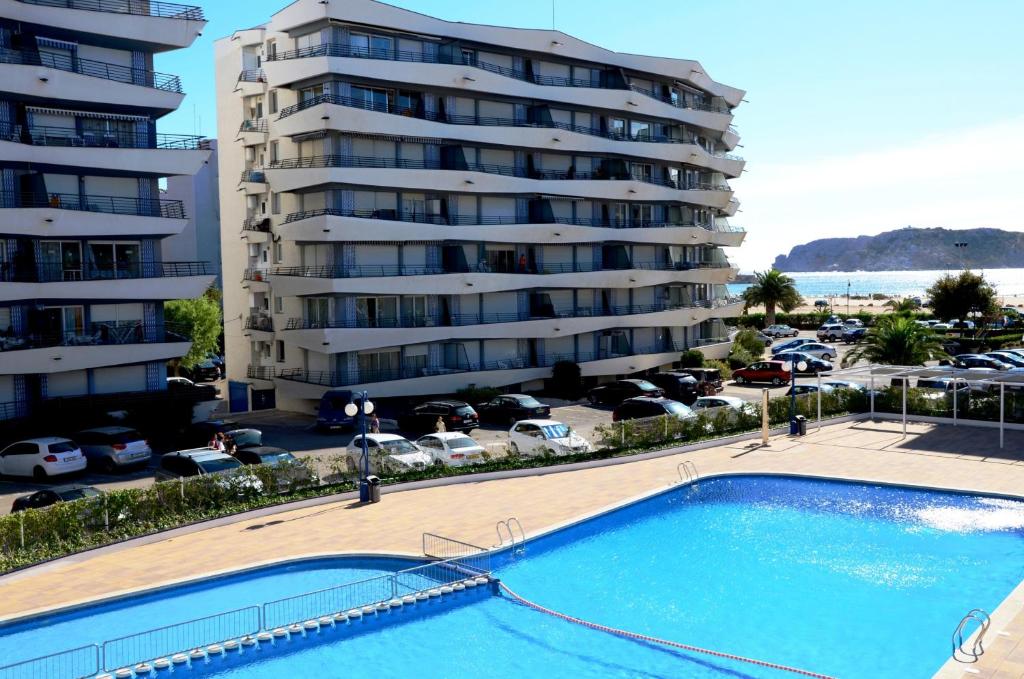 una piscina di fronte a un grande condominio di ROCAMAURA III BX-9 a L'Estartit