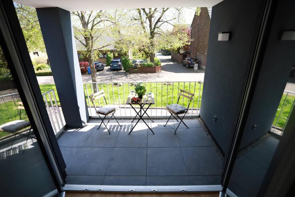 a porch with two chairs and a table on it at Ganzes Apartment -London- in Erftstadt - 3 Zimmer & 63qm - nahe Köln, Messe, Phantasialand & Bonn - Familienurlaub oder Business Trip in Erftstadt