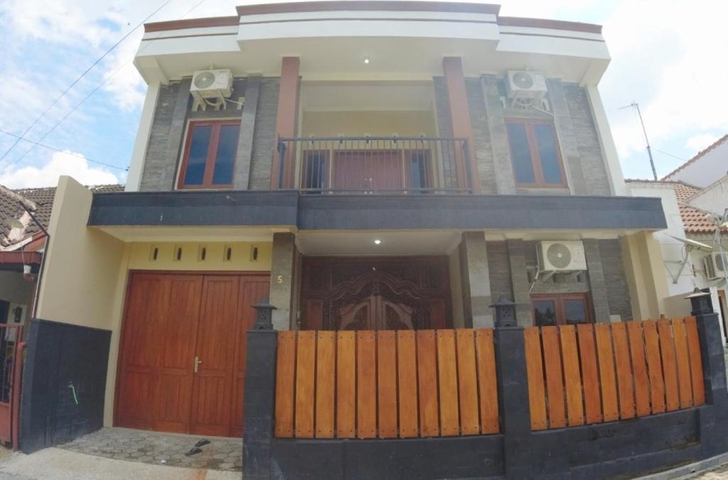 une grande maison avec des portes brunes et une clôture dans l'établissement Eltanin Homestay by FH Stay, à Salakan
