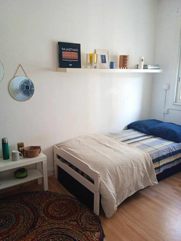 a bedroom with a bed and a lamp and a table at Chambre cosy chez Schéhérazade in Toulon