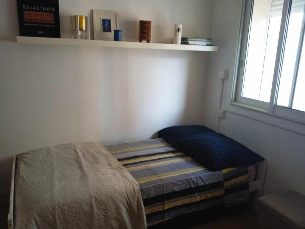 a small bed in a room with a window at Chambre cosy chez Schéhérazade in Toulon