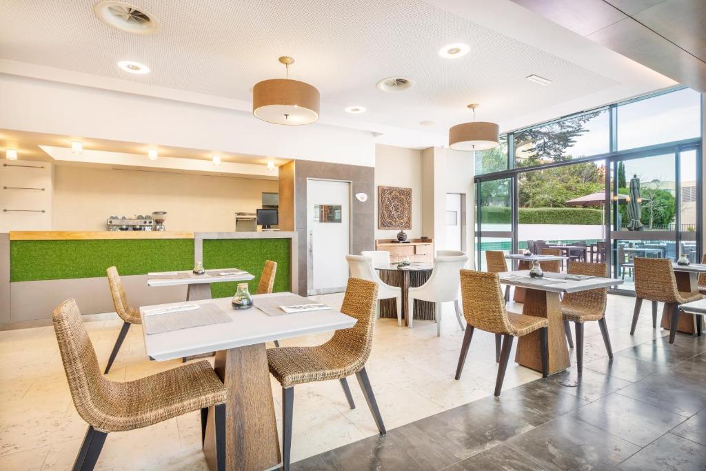 a restaurant with tables and chairs and windows at Palácio Estoril Hotel, Golf & Wellness in Cascais
