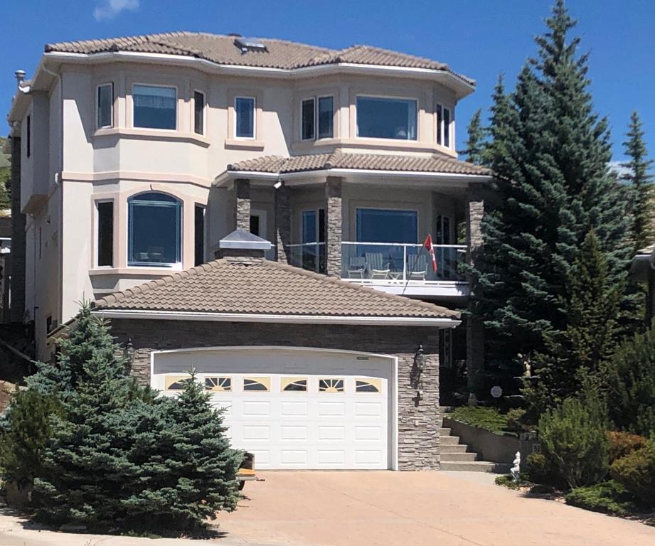 uma casa grande com uma porta de garagem branca em Rocky Mountain View Bed & Breakfast em Cochrane