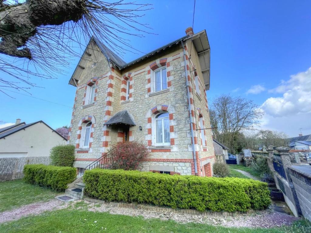 ein altes Backsteinhaus mit Büschen davor in der Unterkunft Charmant Gîte Familial avec Jardin Privatif et Confort Moderne, au Cœur de la Touraine - FR-1-381-550 in Sepmes