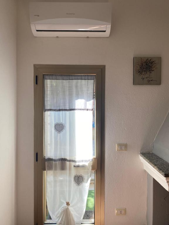 una puerta con una ventana con una cortina en Milly's House, en Siniscola