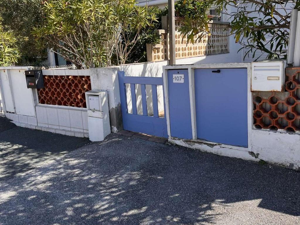 une clôture avec une porte bleue et un portail dans l'établissement Maison 3 pièces, mezzanine, 6 couchages, terrasse, clim, à 80m de la plage - Port-la-Nouvelle - FR-1-229C-88, à Port-la-Nouvelle