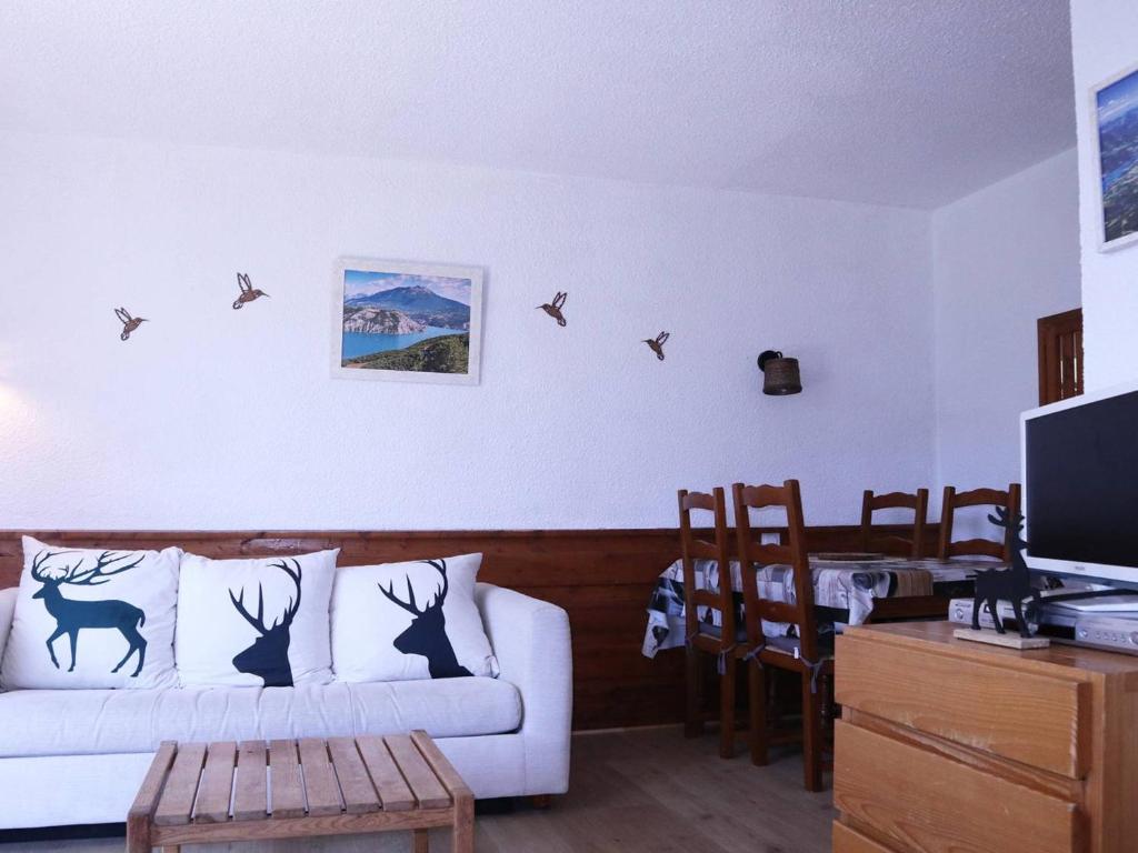 sala de estar con sofá blanco y pájaros en la pared en Appartement Les Orres, 1 pièce, 6 personnes - FR-1-322-534, en Les Orres
